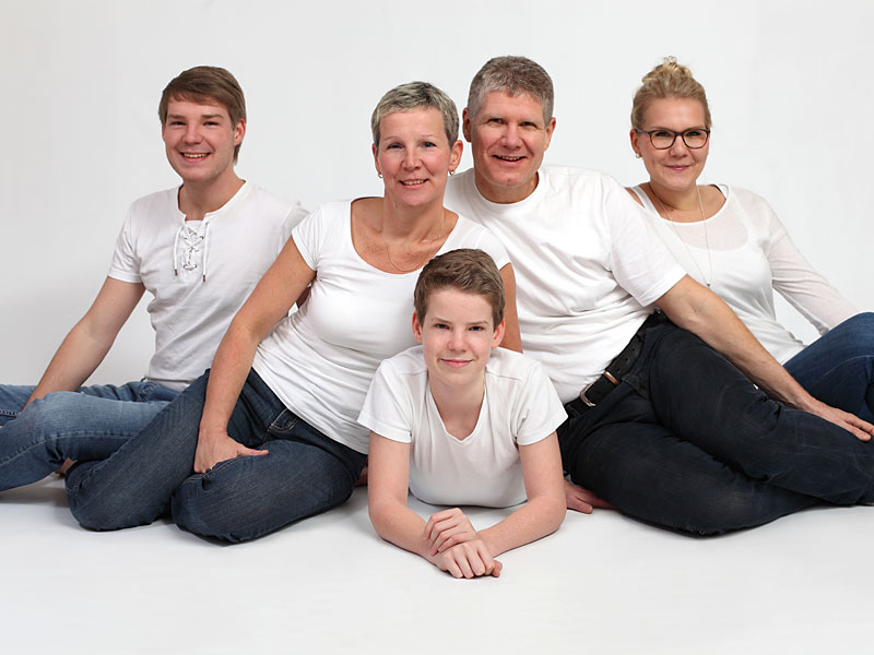 Familie in weißen Shirts und dunklen Hosen zum Familienshooting.