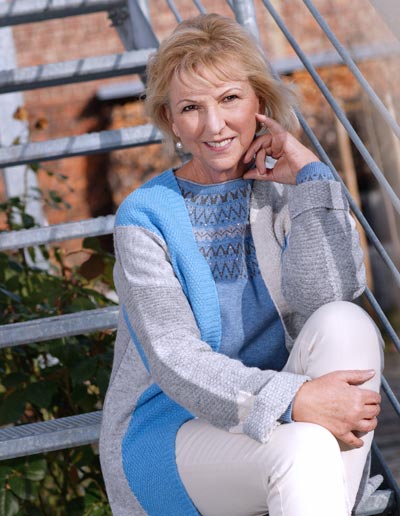 Business-Portrait Blonde Frau sitzt auf Treppe in der Natur